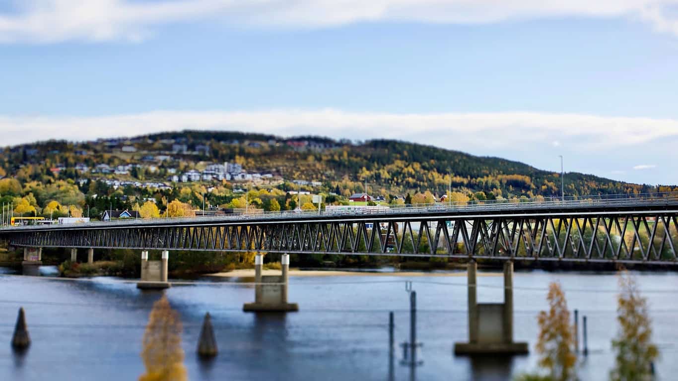 Bildet viser Fetsund bruer over Glomma med boligbebyggelse og skog i åsene, brukt som illustrasjon i artikkel om beste eiendomsmegler i nettopp dette området.