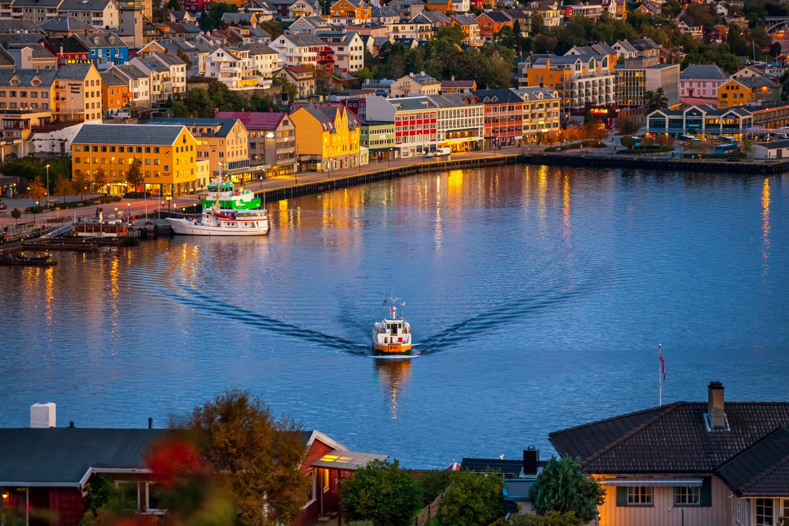 Oversiktsbilde av Kristiansund med Sundbåten i havna og fargerik sentrumsbebyggelse langs kaikanten, illustrasjonsbilde til guide om eiendomsmegler på Nordmøre.